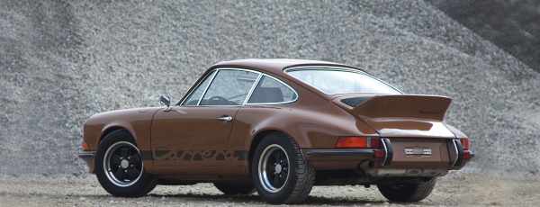 A brown Porsche 911 Carrera RS on gravel